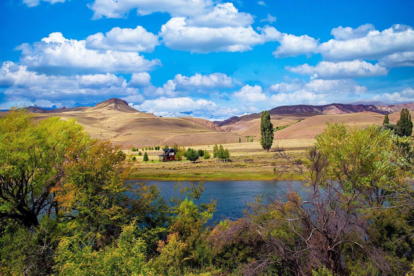 Un lago entre montañas, árboles y nubes